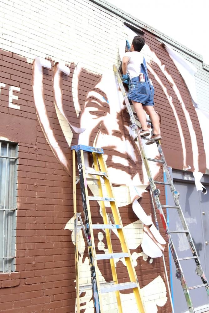 Muralist work on piece in protest of proposed arena at Duranguito. 