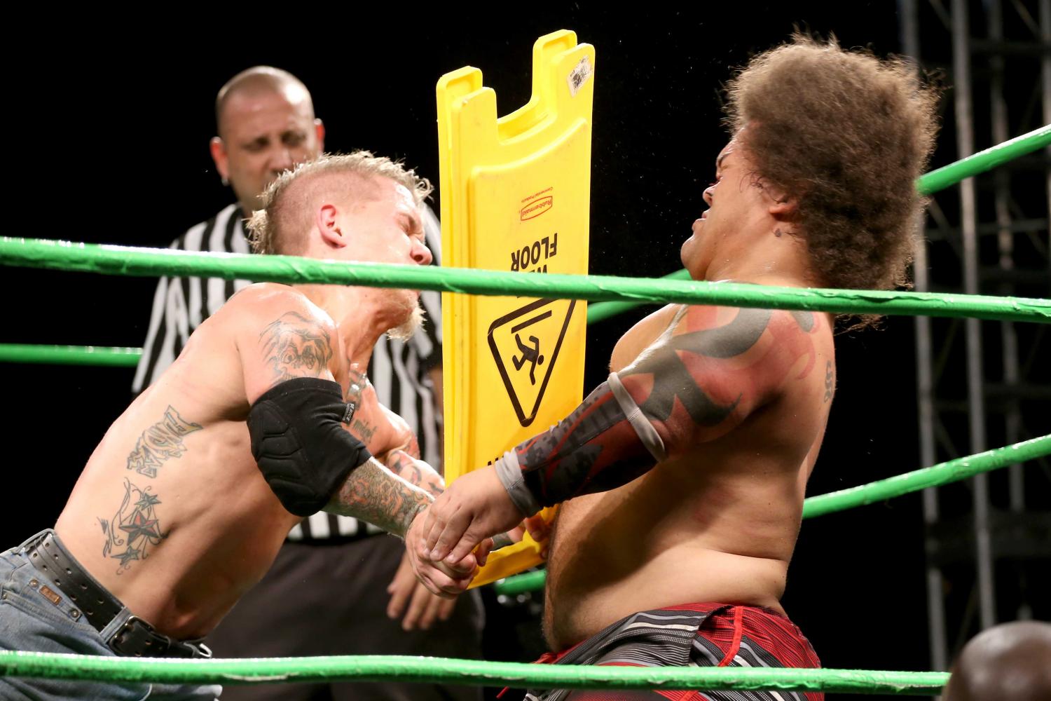 Cowboy Kid Quick uses a 'Wet floor' sign to hit King Samoa.