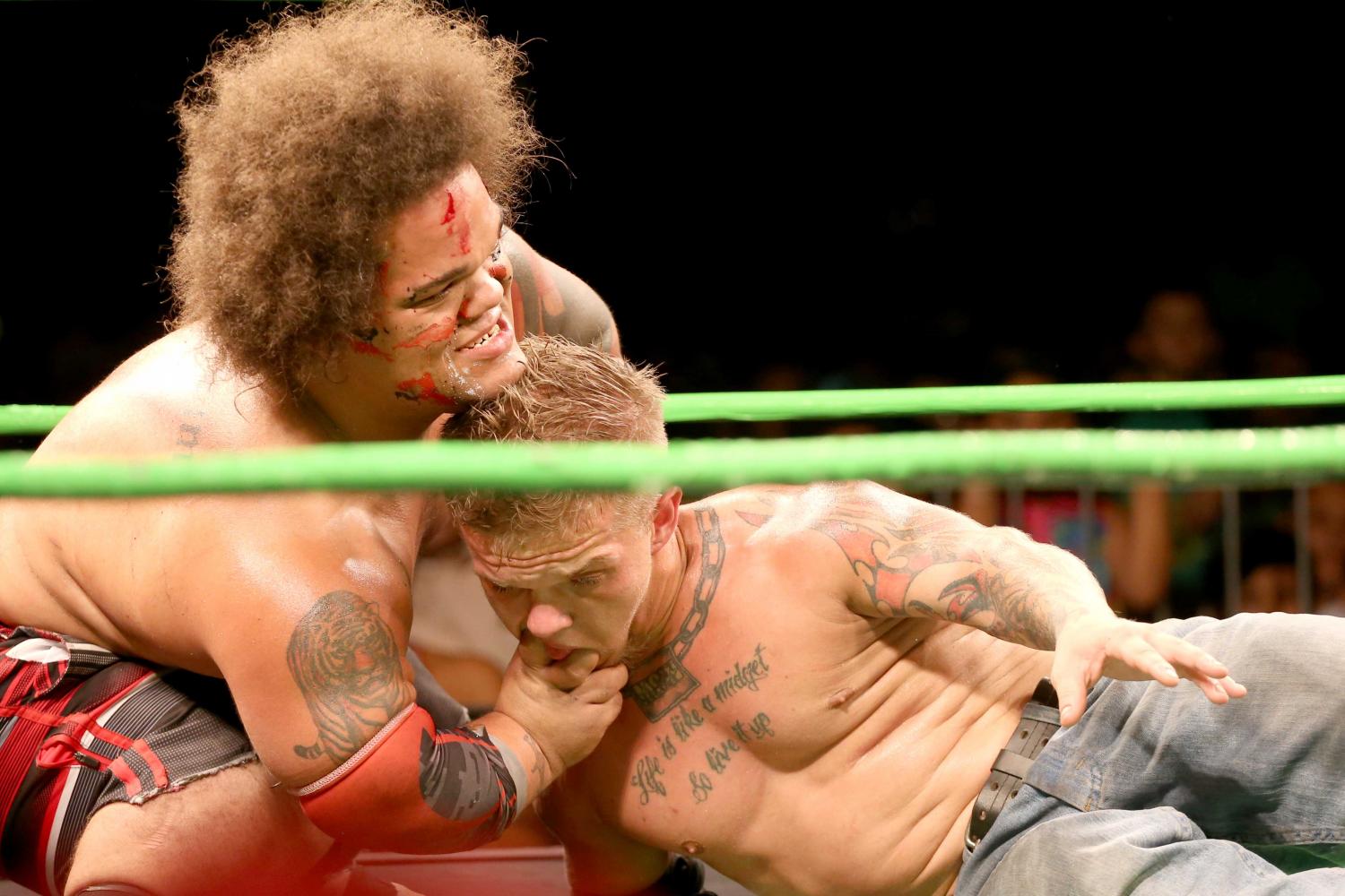 King Samoa sticks his fingers inside of MCW champion Cowboy Kid Quick's mouth.