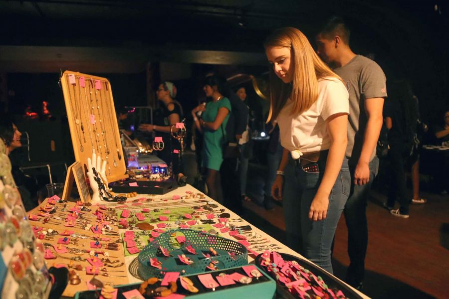 Attendees walk around and check out the art from local vendors at the Last Thursdays Art Market at Tricky Falls.