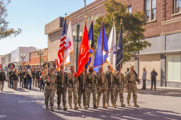 Starting off the parade, U.S. military branches walk in unison raising their flags.