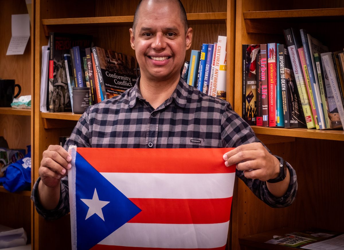 UTEP professor of Sociology and Anthropology Dr. Victor Vázquez, a proud Puerto Rician holding his homeland flag to pay respect to his new book about the gentrification of Puerto Rico.