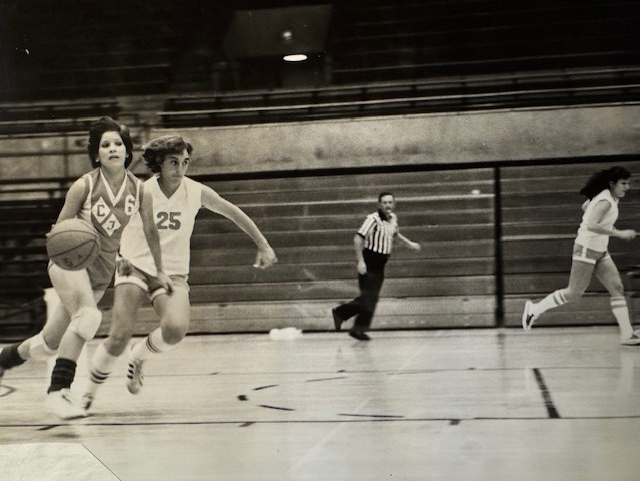 Women's basketball member Judy Marsh presented photos to Carol Ammerman in scrapbooks at the end of the first season. Photo courtesy of Carol Ammerman. 