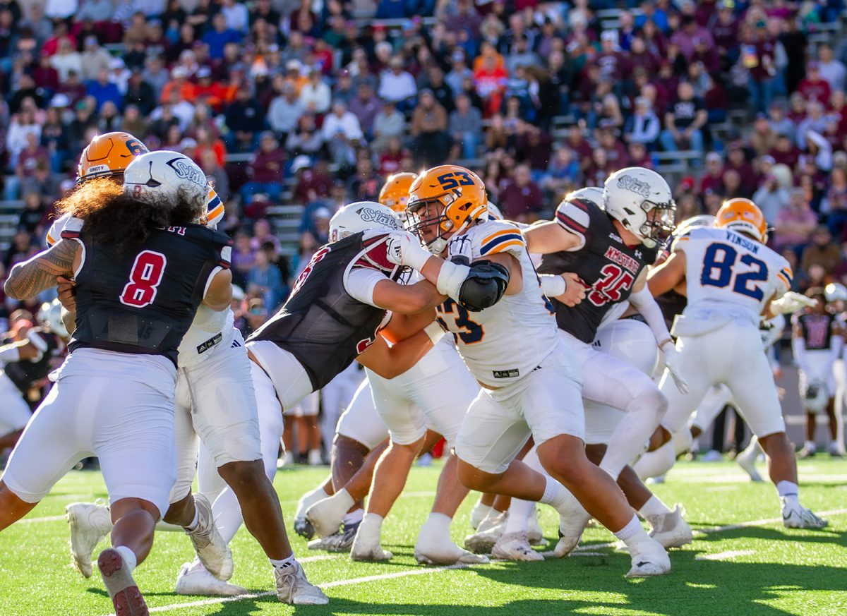 UTEP football players play defense against NMSU.