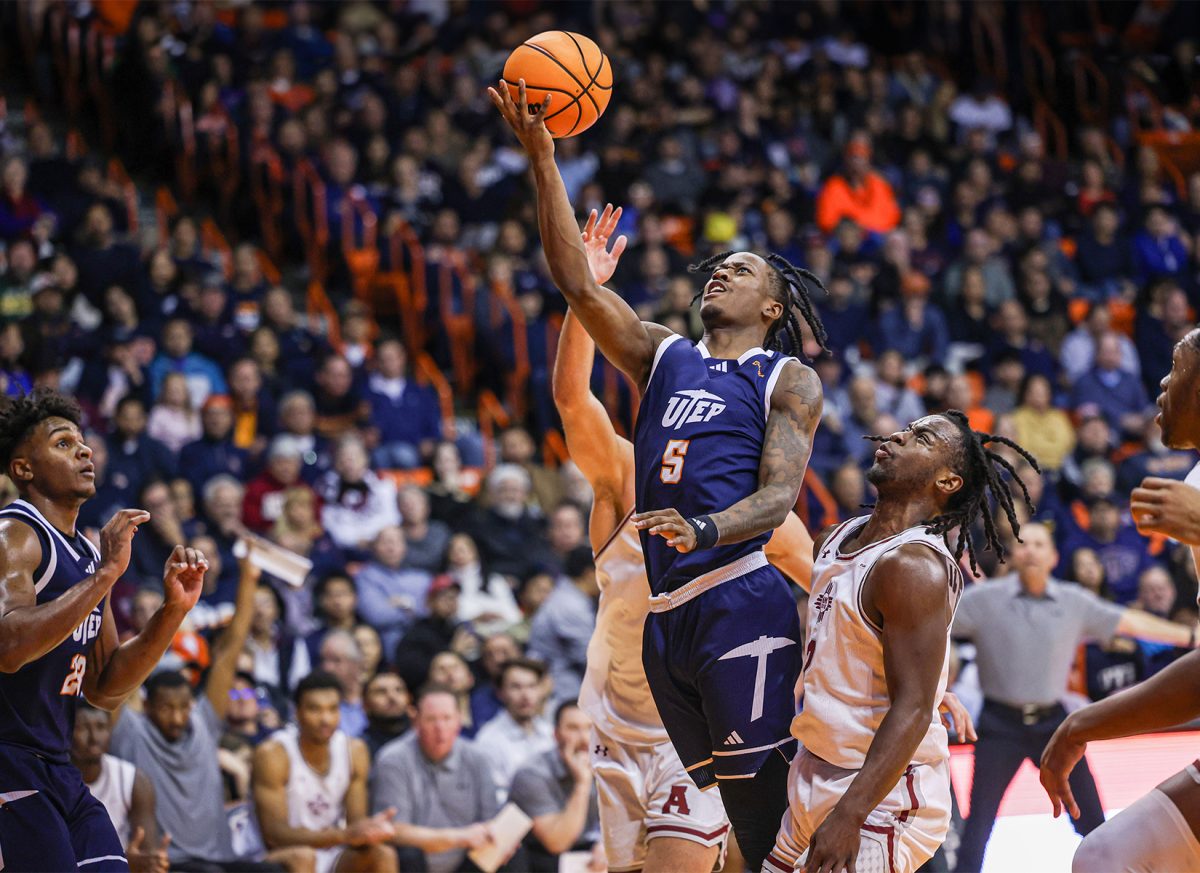 Senior Guard David Terrell Jr. goes in for a layup the ball while having two NMSU players guarding the net. Photo by Diego Cruz-Castruita. 