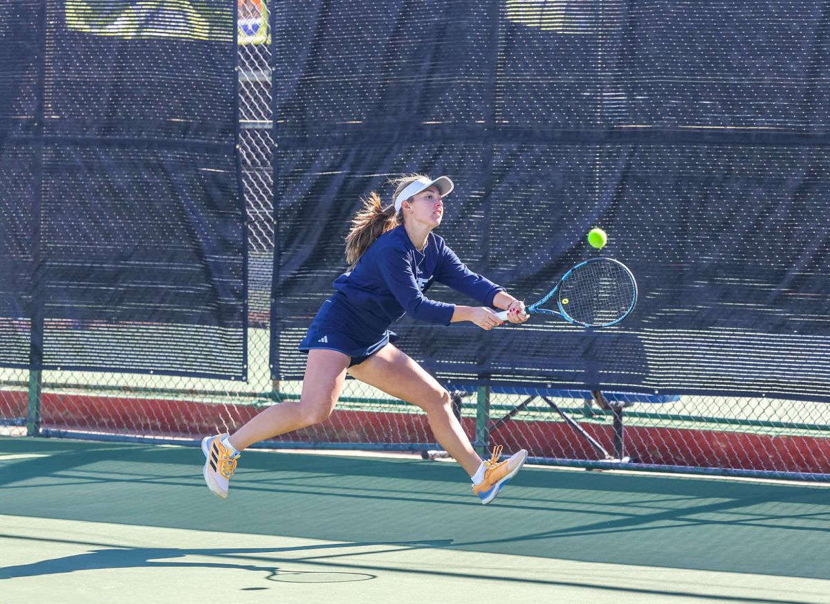 Sr. Carlotta Mecaglia stretches her entire body with precision to strike the tennis ball.