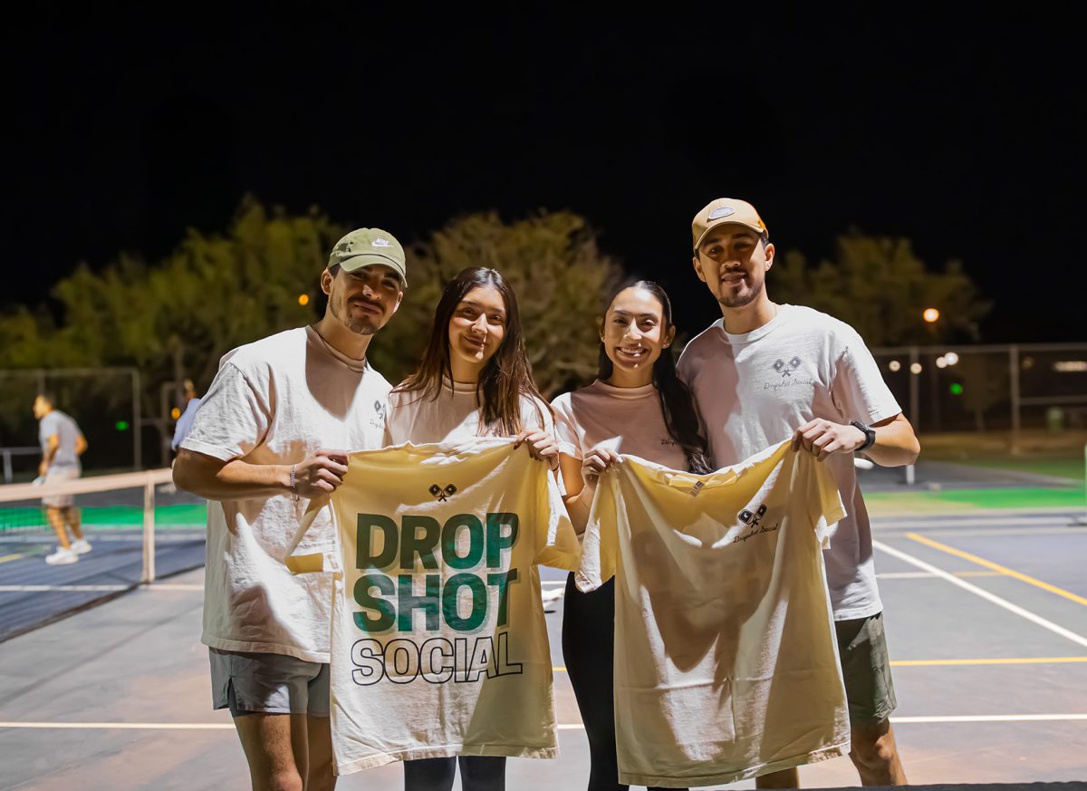 Attendees proudly display their new Dropshot Social merchandise while enjoying a night of pickleball.