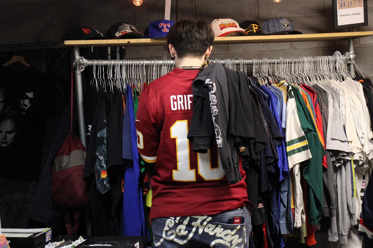 A customer at the Rodeo Night Market browses through the selection of vintage football jerseys.