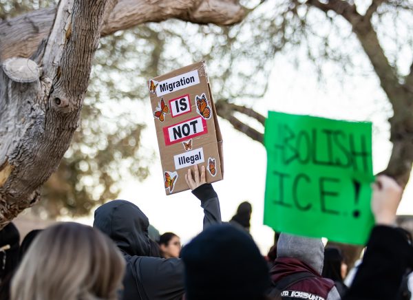 A demonstrator raises a sign reading "Migration is not illegal" during a Jan. 29 protest.