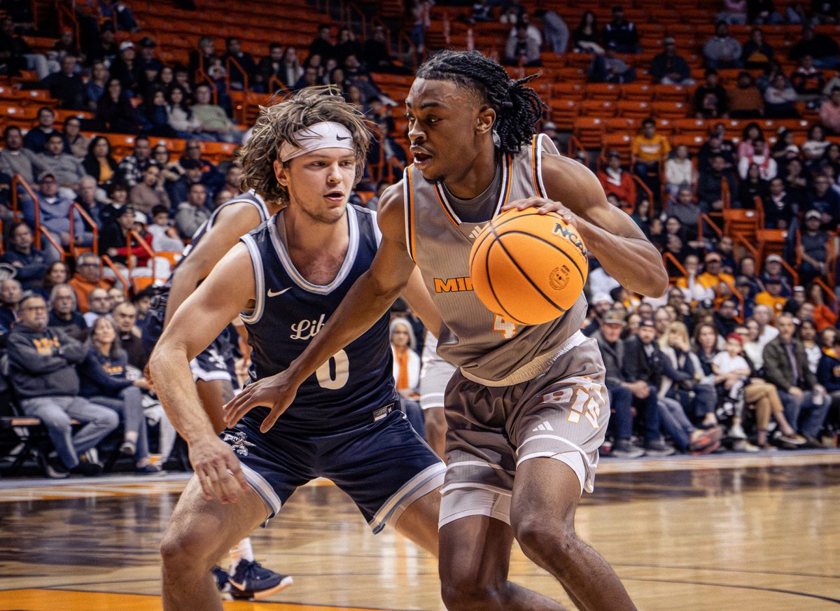 Seninor guard Corey Camper Jr. avoids Liberty player on Feb. 15. Camper put up 10 points against the Liberty Flames.