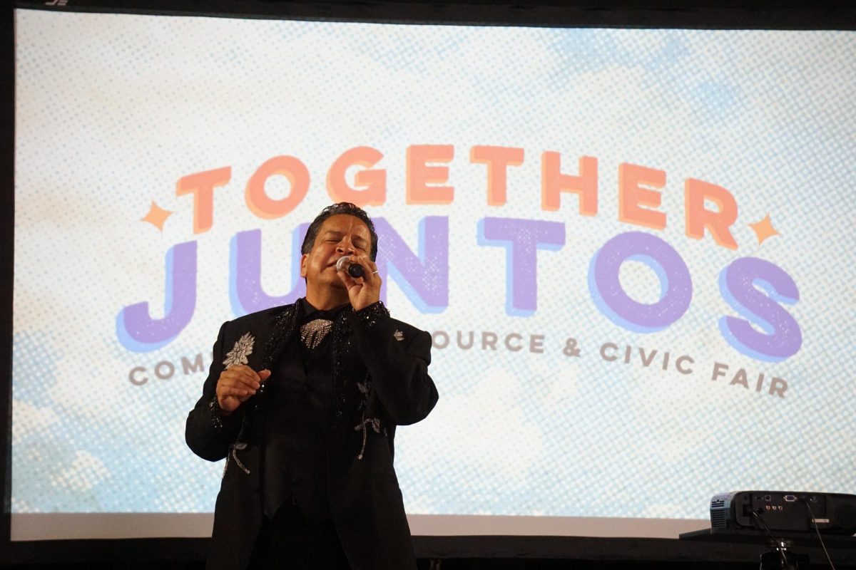 A Juan Gabriel impersonator performs at 'Together Juntos' to offer the attendees some musical relief as they collect information on organizations and services that may be helpful to them.